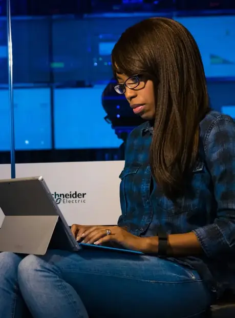 A woman working on a device in a technology environment.
